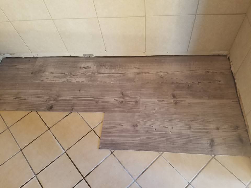 New plank flooring transitioning into existing tile