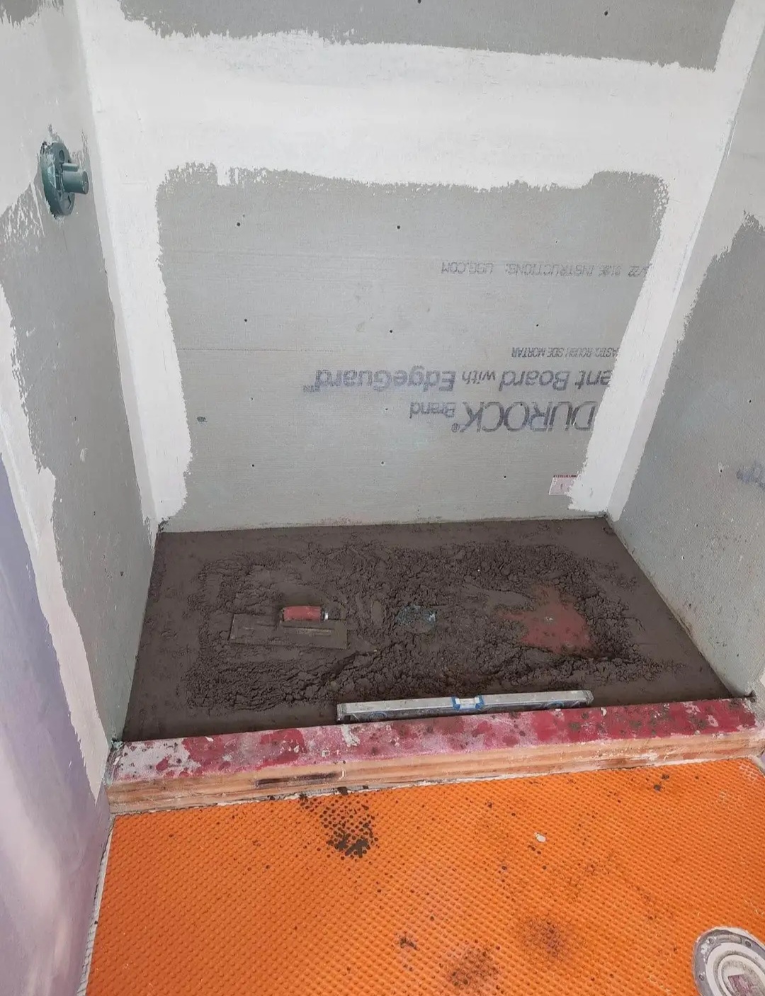 Custom shower pan mortar bed being sloped to the drain