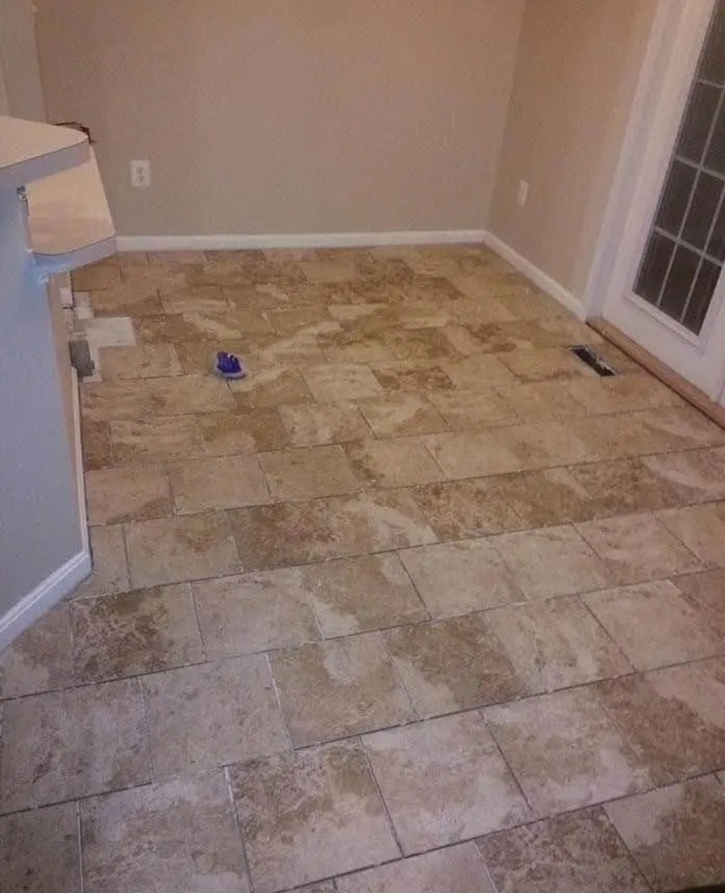 Existing natural stone tile floor before renovation